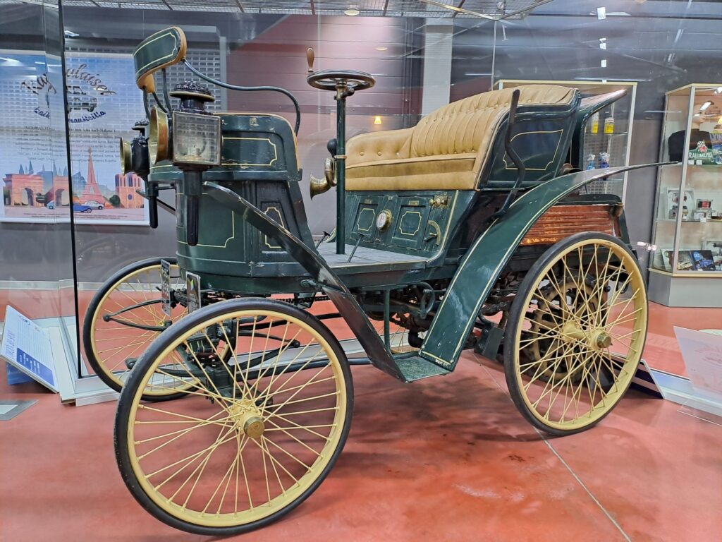 Näyttelytilassa kuvattu vanhan hevoskärryn näköinen ajoneuvo 1800-luvun lopulta.